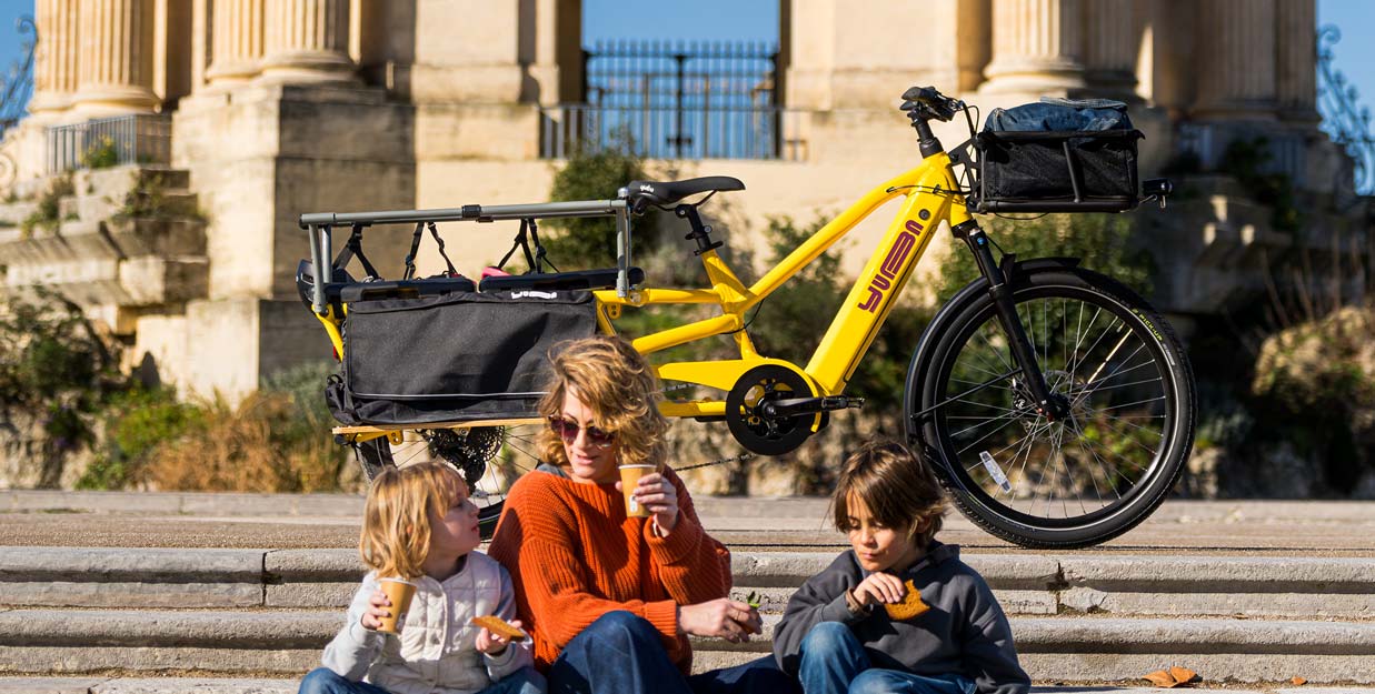 Mutter mit zwei Kindern vor einem Yuba Spicy Curry Longtail Lastenrad